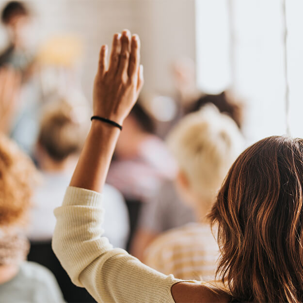 Back view of a woman raising her arm on a seminar